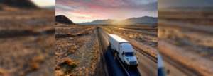 White Semi-Trailer Truck Heading down a four-lane Highway at Dusk